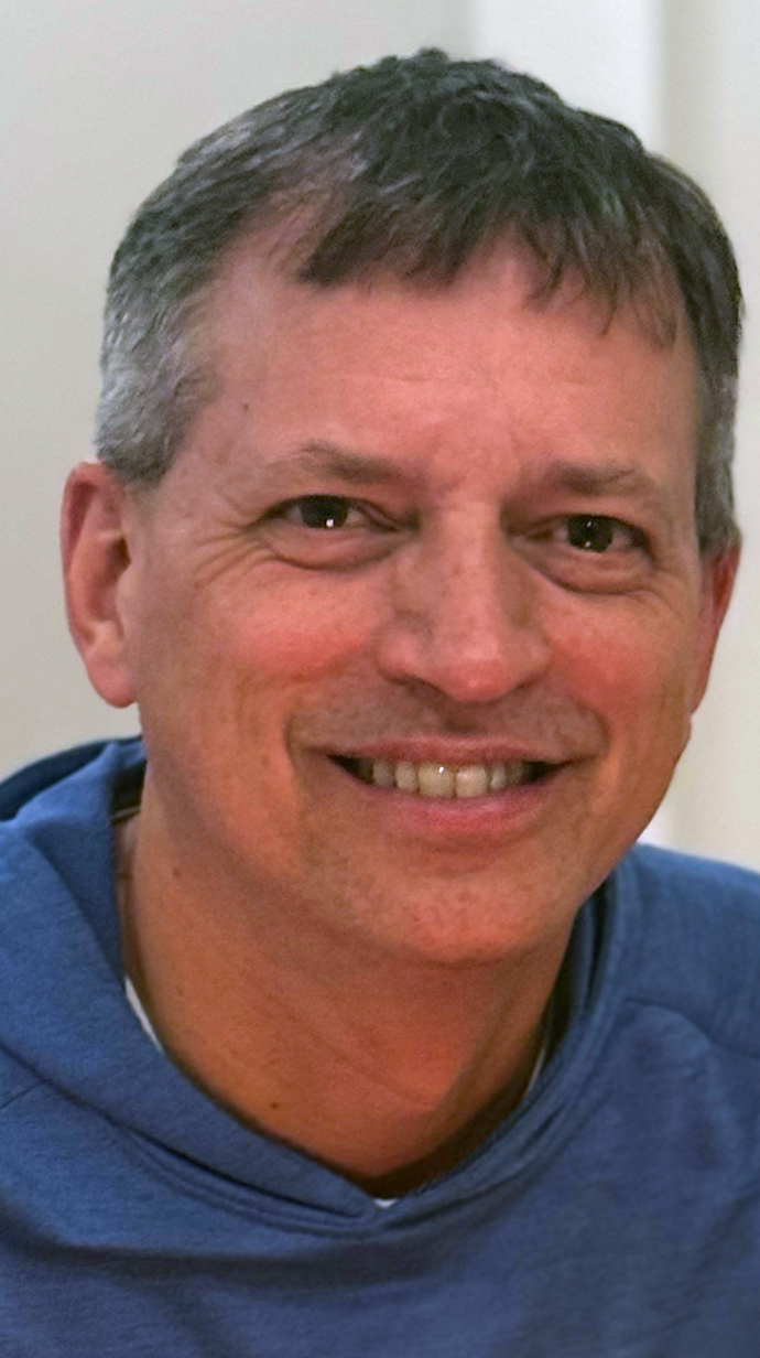 Headshot of a man wearing a blue sweatshirt.