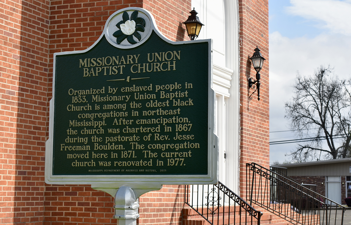 A historical marker in front of a brick building reads 'Missionary Union Baptist Church.'