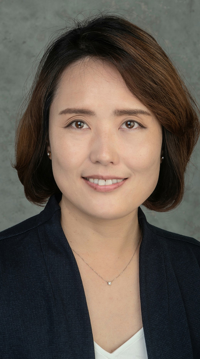 Headshot of a woman wearing a dark jacket over a white blouse.