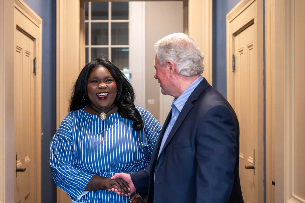 Chancellor Glenn Boyce shakes Aminata Ba's hand in the hallway near his office. 