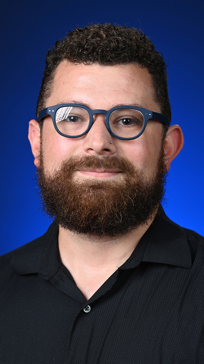 Headshot of a man wearing glasses and a black shirt