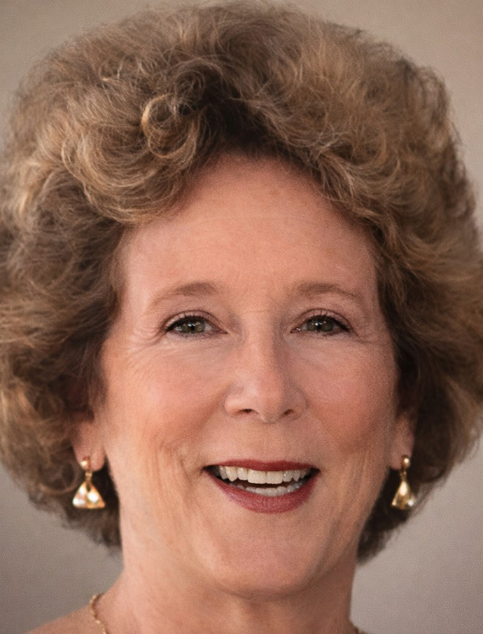 Headshot of a woman with styled hair and earrings.