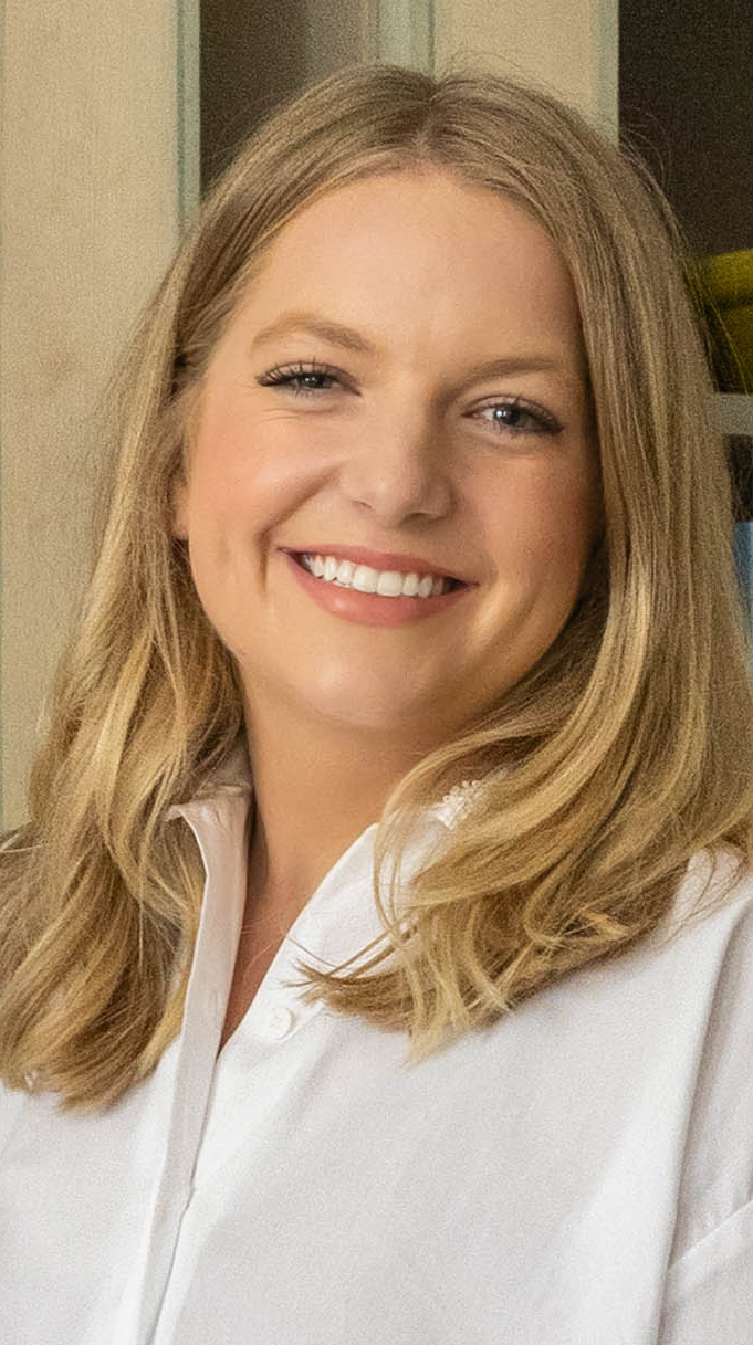 Headshot of a woman wearing a white dress.