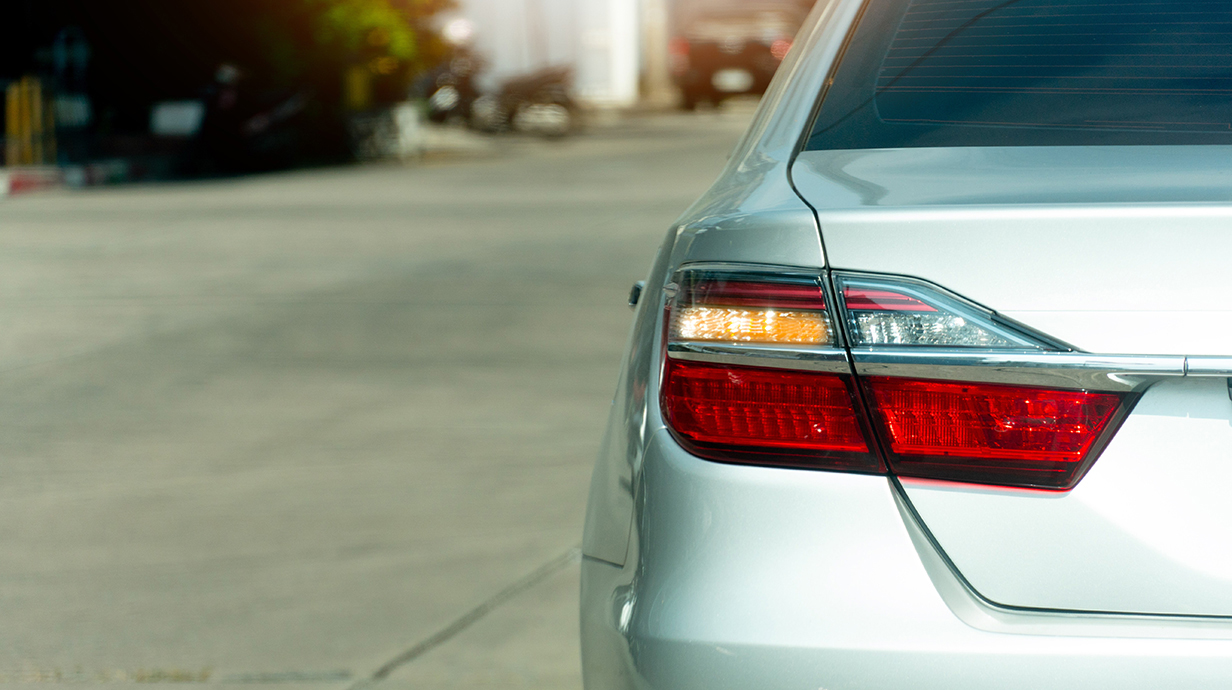 A car sits at an intersection with its left turn signal lit.