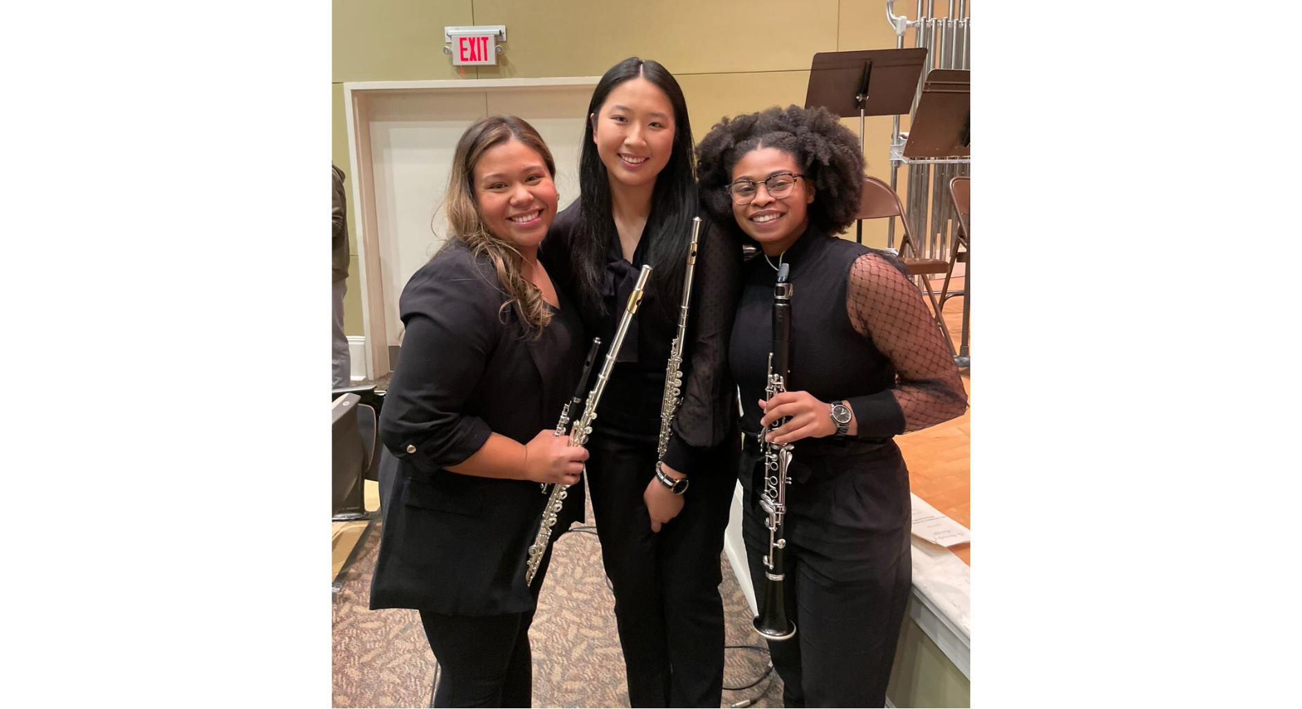 An image of Britney Tzib, Linna Zheng, and Lindsee Washington smiling and holding wind instruments.