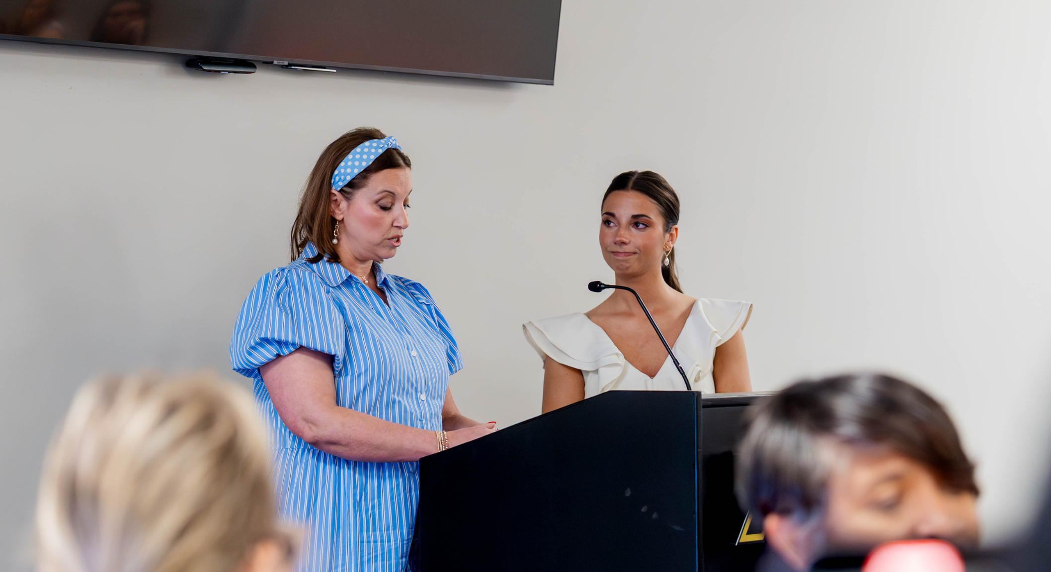 Image of Melanie and Avery Tapp speaking at a podium.