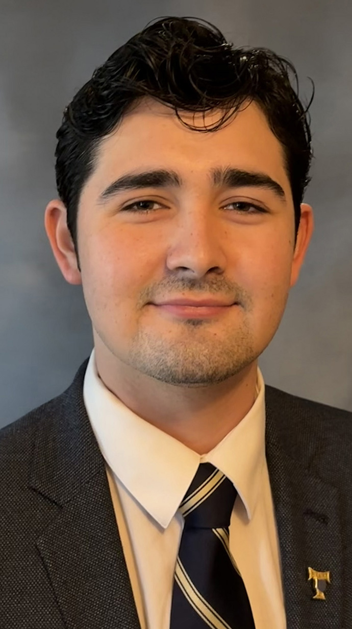 Headshot of a young man wearing a dark suit.