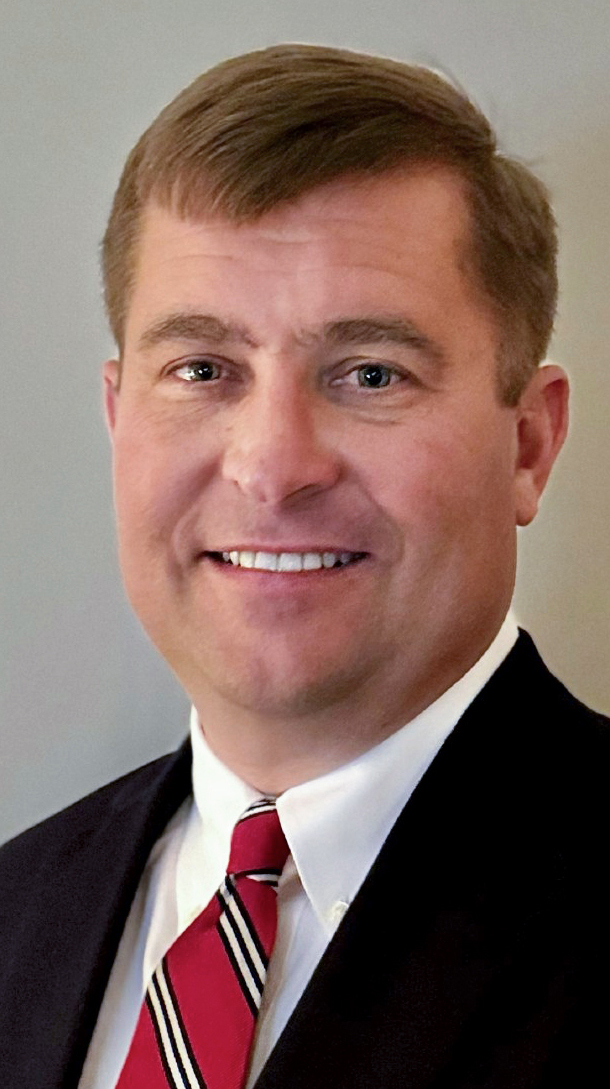 Headshot of a man wearing a dark suit.