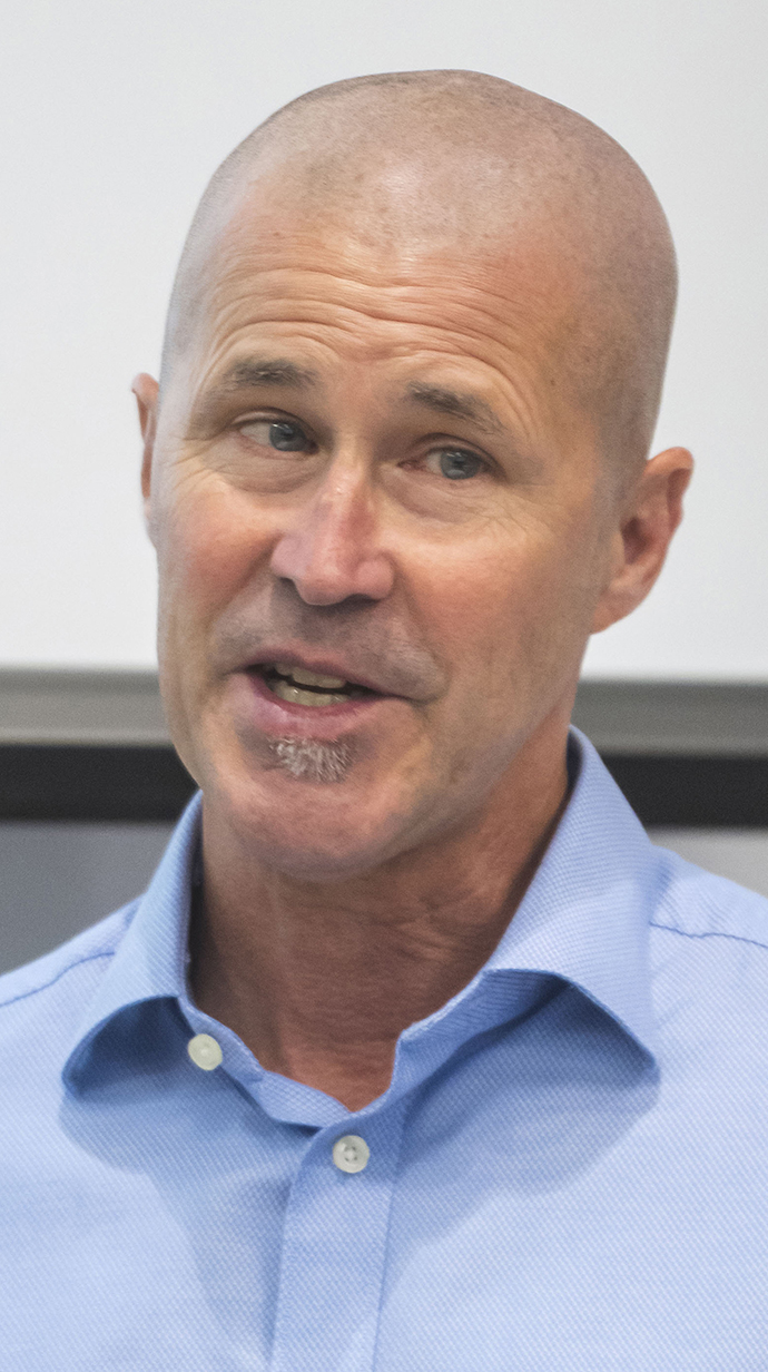 Headshot of a man wearing a blue button-up shirt.