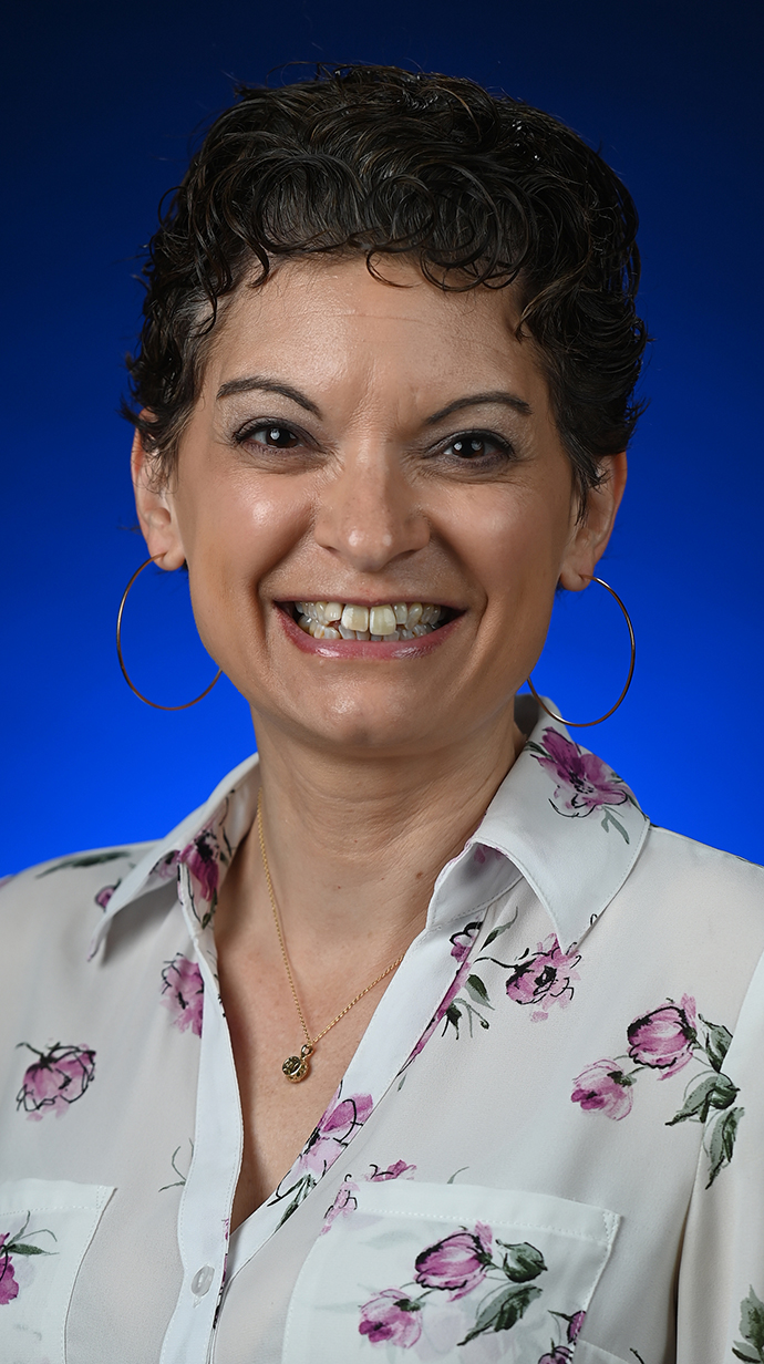 Headshot of a woman wearing a floral print blouse.