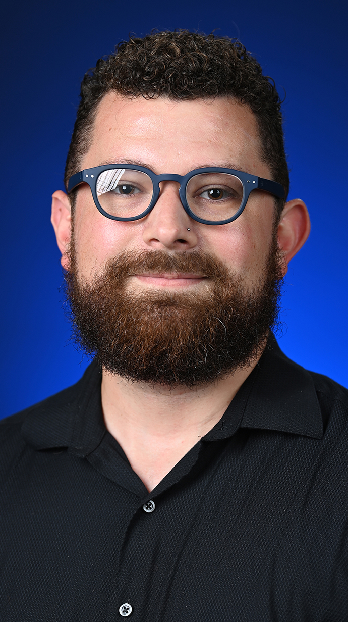 Headshot of a man wearing glasses and a black shirt.