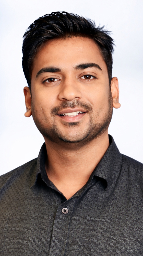 Headshot of a young man wearing a casual brown shirt.