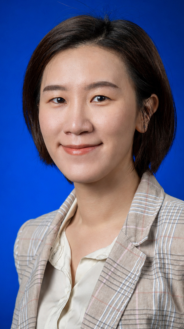 Headshot f a woman wearing a tan plaid jacket over a light-colored shirt.