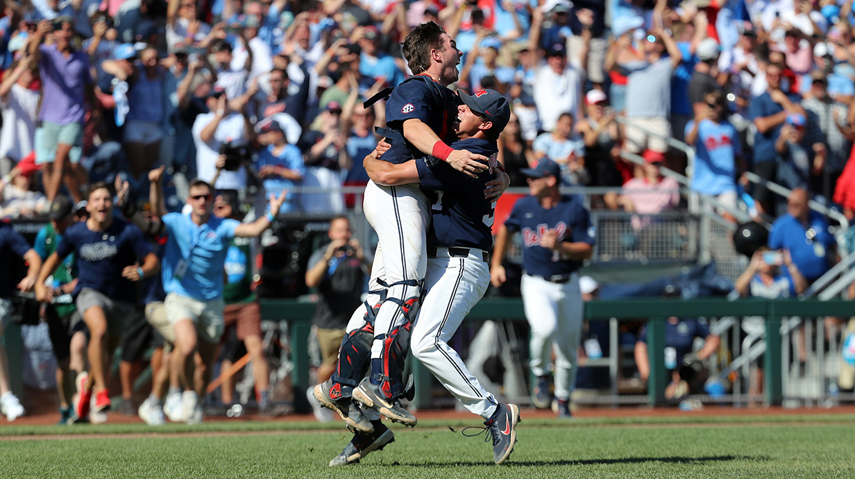 Two baseball players celebrate a big play in the infield of a stadium.