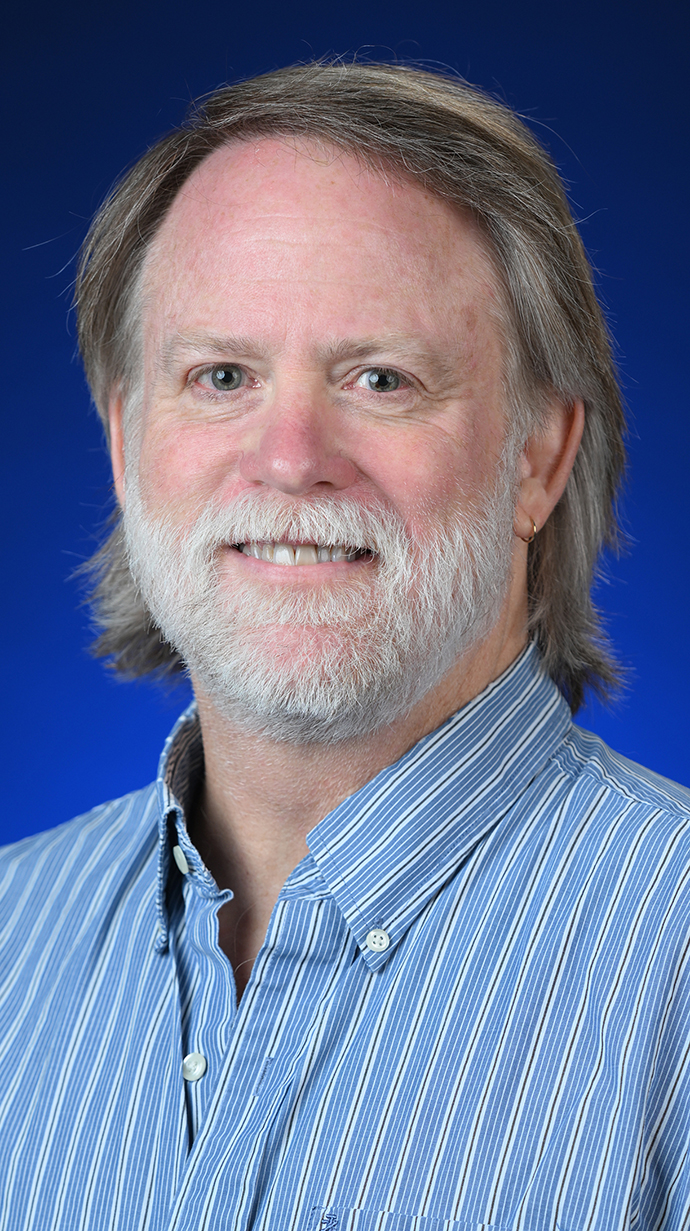 Headshot of a man wearing a blue shirt.
