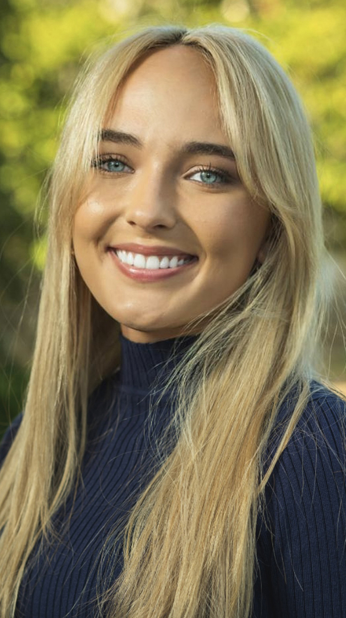 Headshot of a young woman wearing a dark blue sweater.