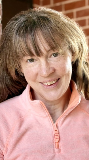 Headshot of a woman wearing a pink shirt.