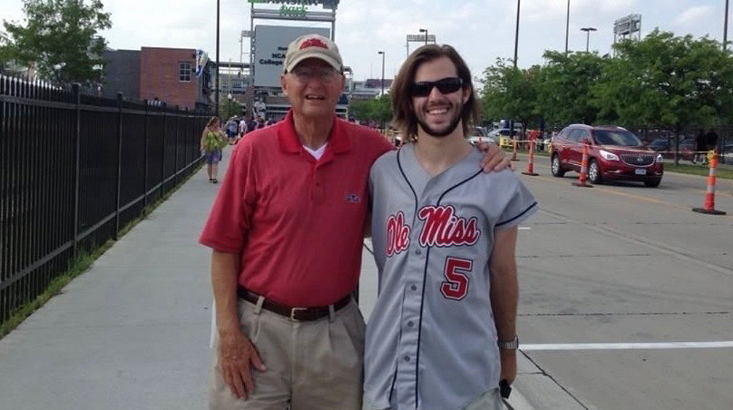 A man and a young man stand outside a stadium.