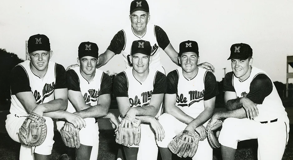 black and white archival photo of baseball players. Coach and back,  5 players kneeling in front