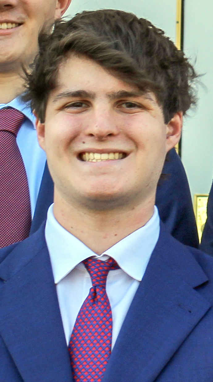 Headshot of a young man wearing a blue suit with a red tie.