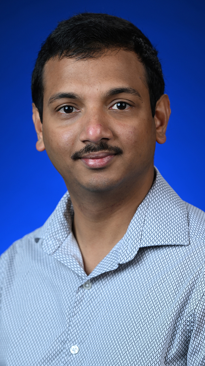 Headshot of a man wearing a light blue shirt.