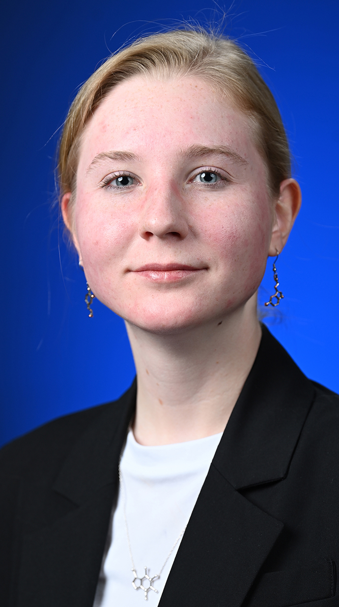 Headshot of a young woman wearing a black jacket over a white blouse.