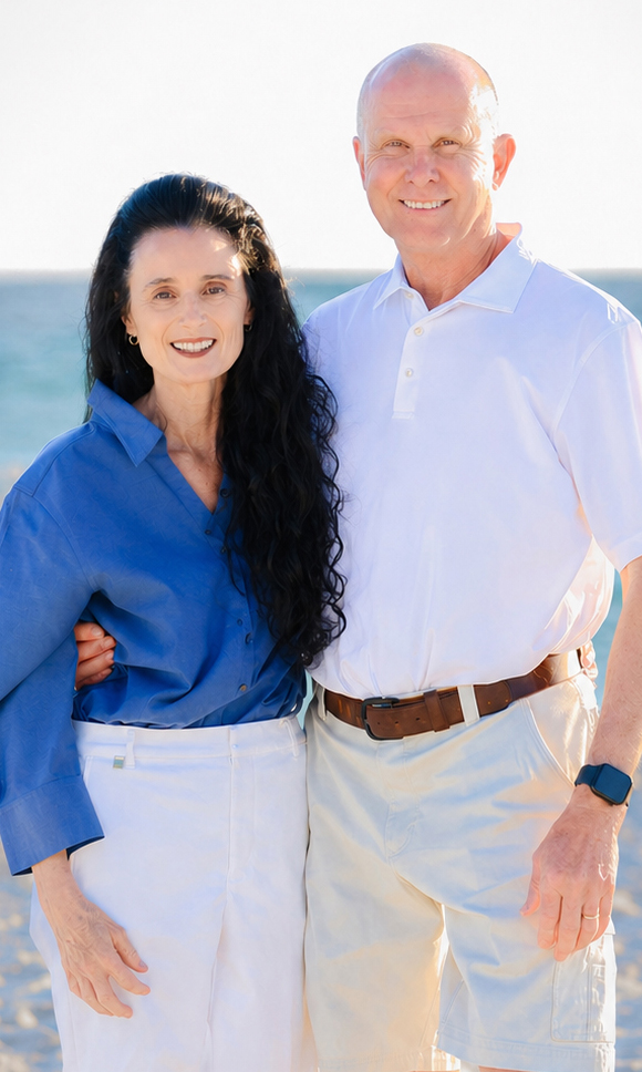 A man and a woman stand on a beach.
