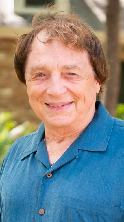 Headshot of a man wearing a blue casual shirt.