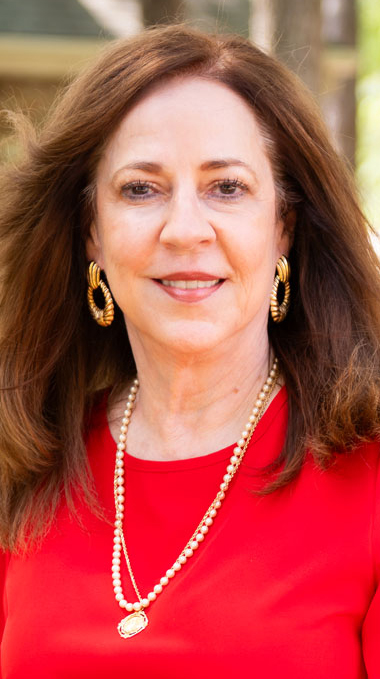 Headshot of a woman wearing a red blouse.