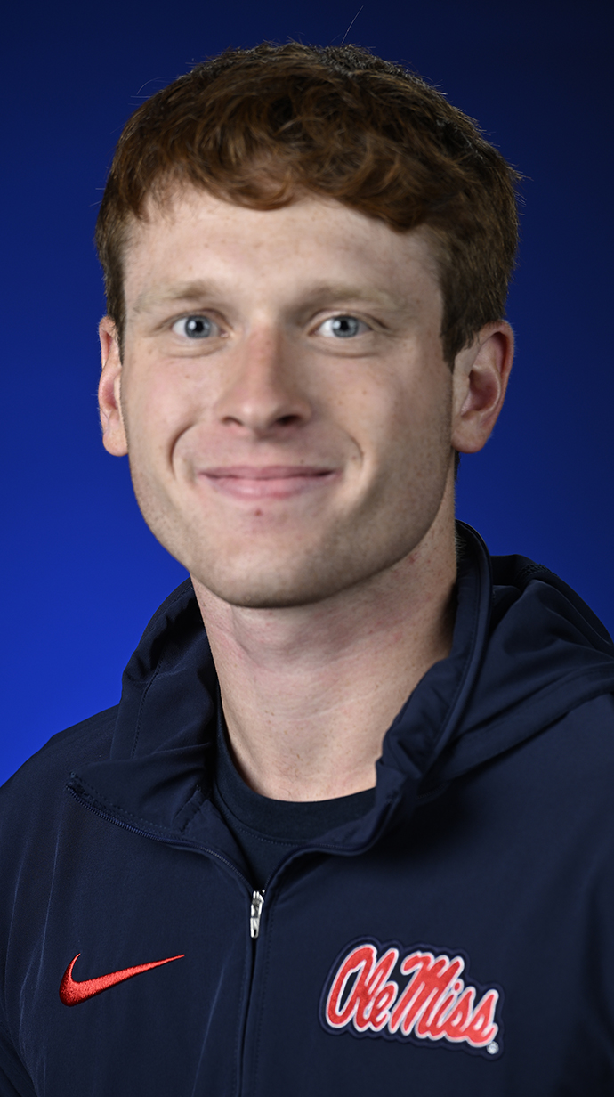 Headshot of a young man wearing a dark blue polo shirt with a red Ole Miss logo.
