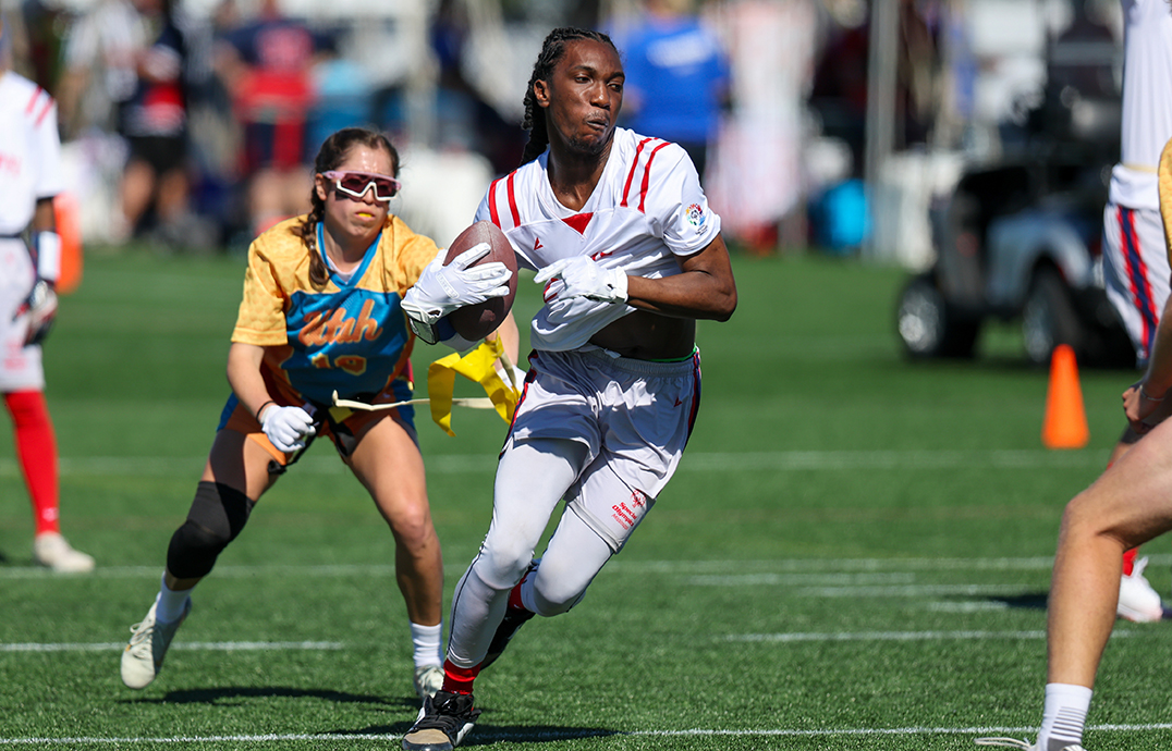 A football player runs with the ball as he dodges other players.