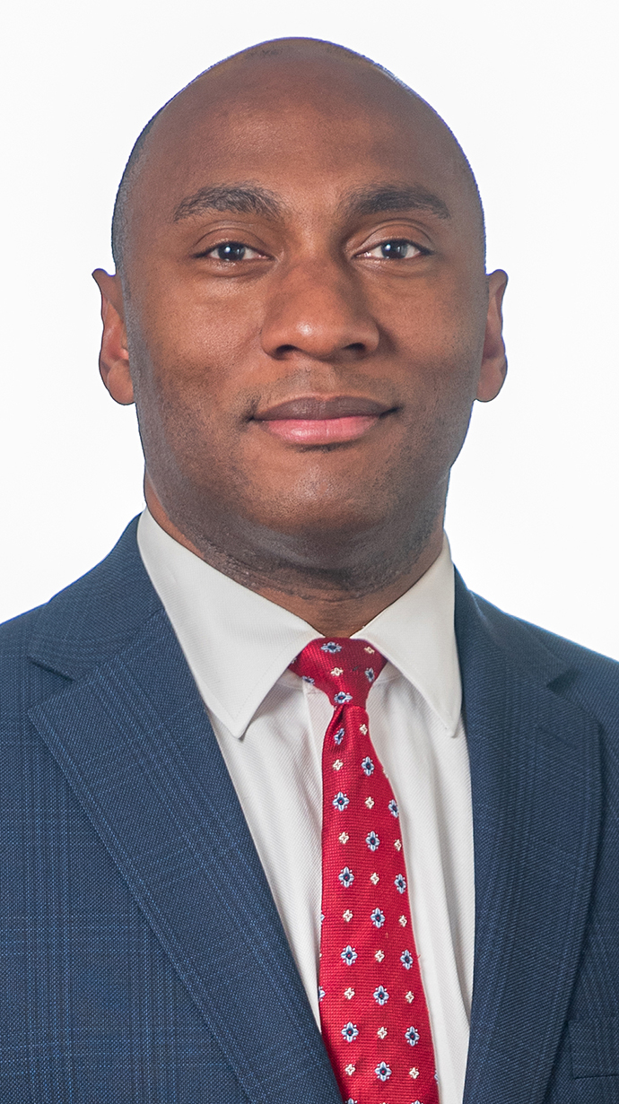 Headshot of a man wearing a blue suit with a red tie.