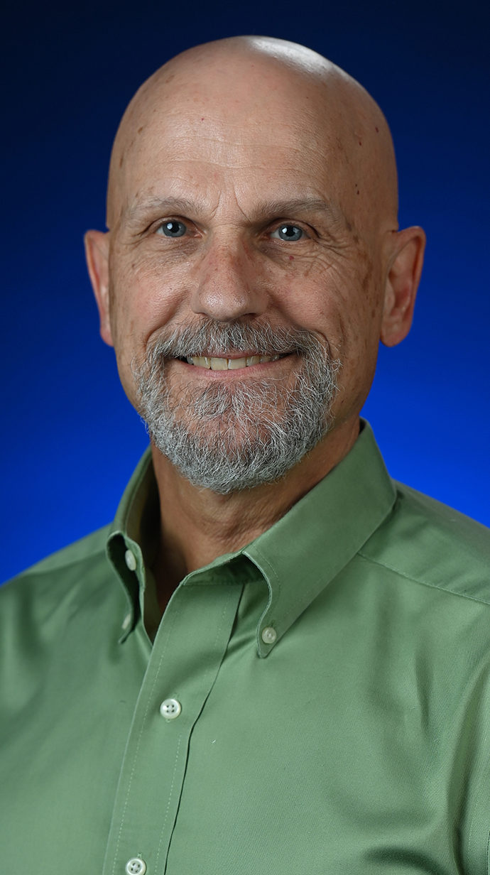 Headshot of a man wearing a green shirt.