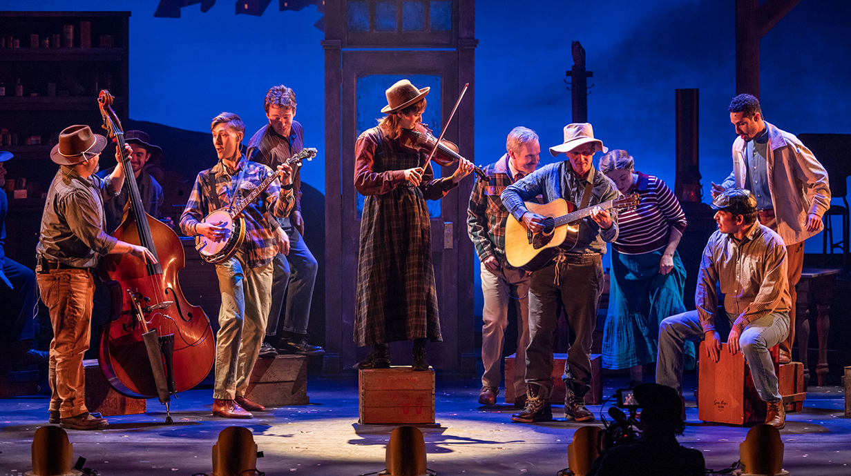 A bluegrass band performs on a stage.