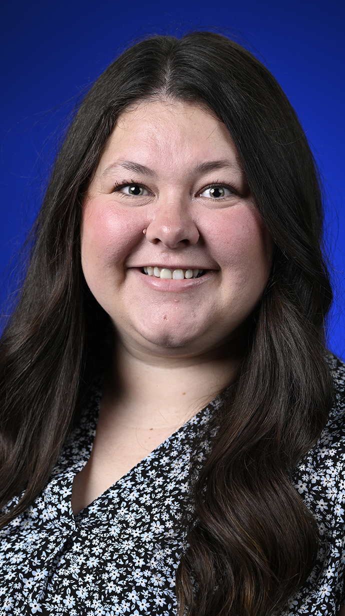 Headshot of a woman wearing a black-and-white patterned blouse.