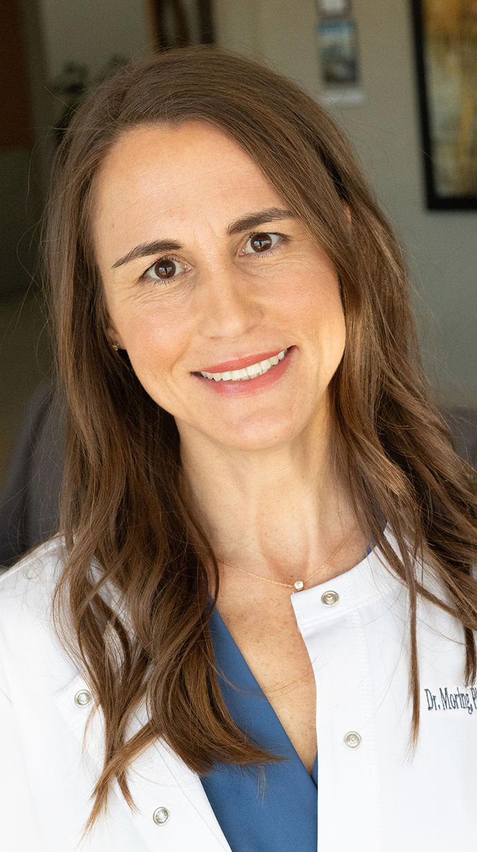 Headshot of a woman wearing medical scrubs.