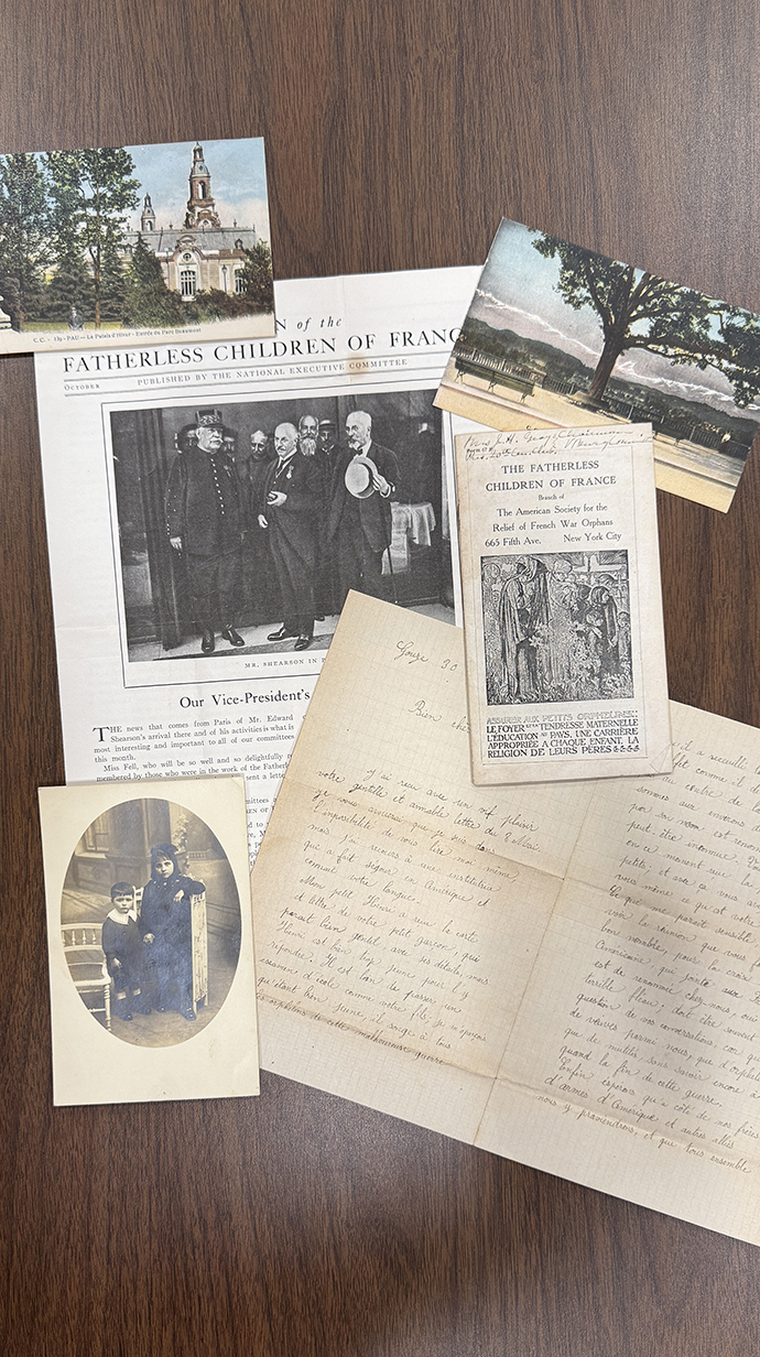 Newspaper clippings, letters and photographs sit on a tabletop.