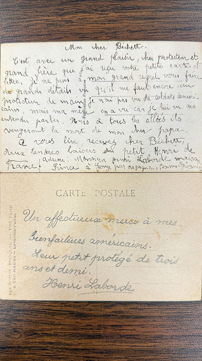 A letter, handwritten in French, sits on a table.