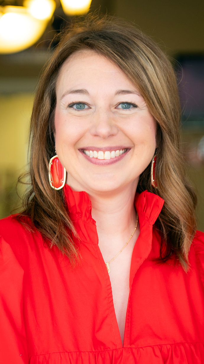 Headshot of a woman wearing a red dress.