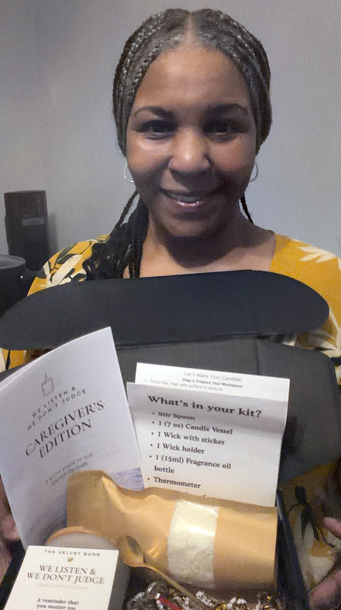 A woman holds a box containing supplies and printed instruction pamphlets.