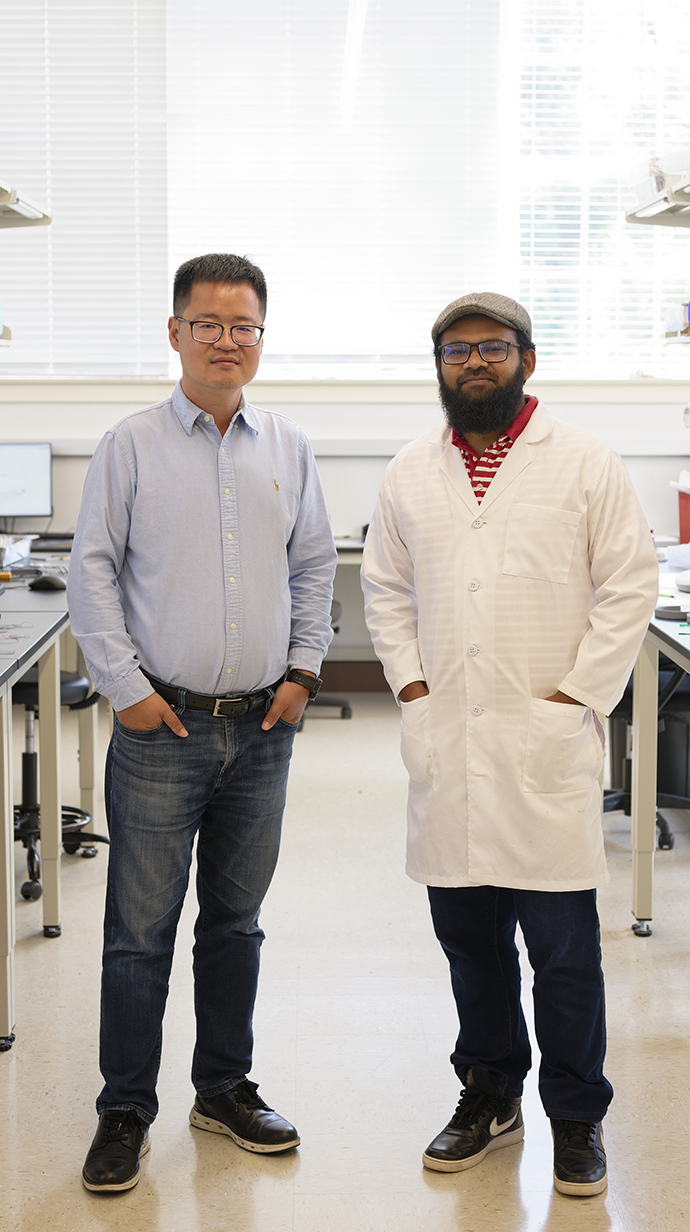 Two men stand in a laboratory.