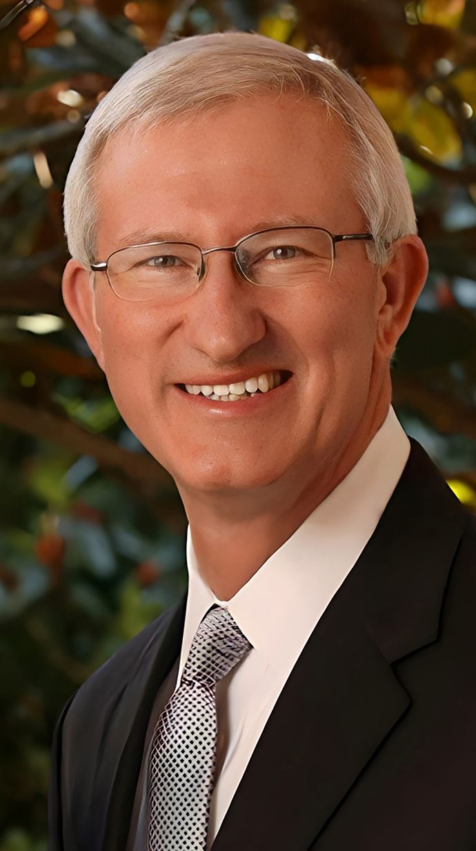 Headshot of a man wearing a dark suit with a black-and-white patterned tie.