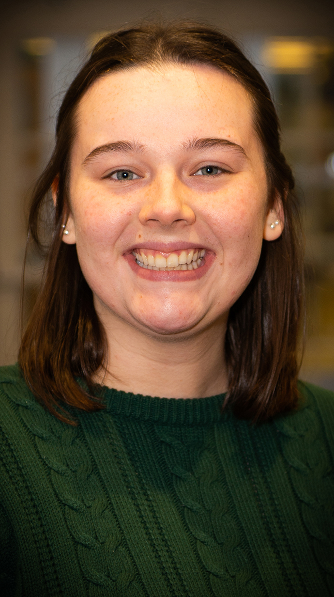Headshot of a young woman wearing a dark green sweater.