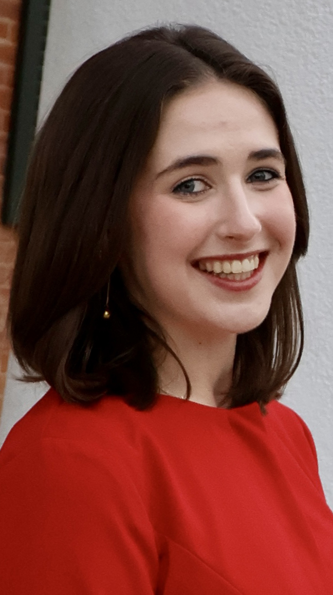 Headshot of a young woman wearing a red dress.