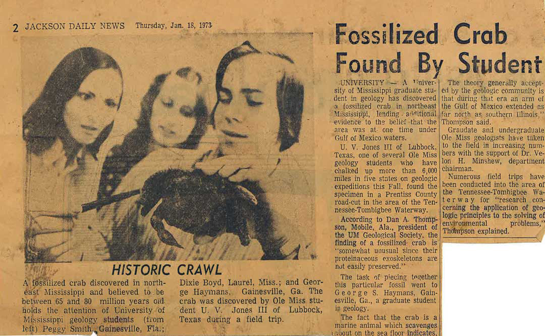 A vintage newspaper clipping shows three young people examining a fossilized crab.