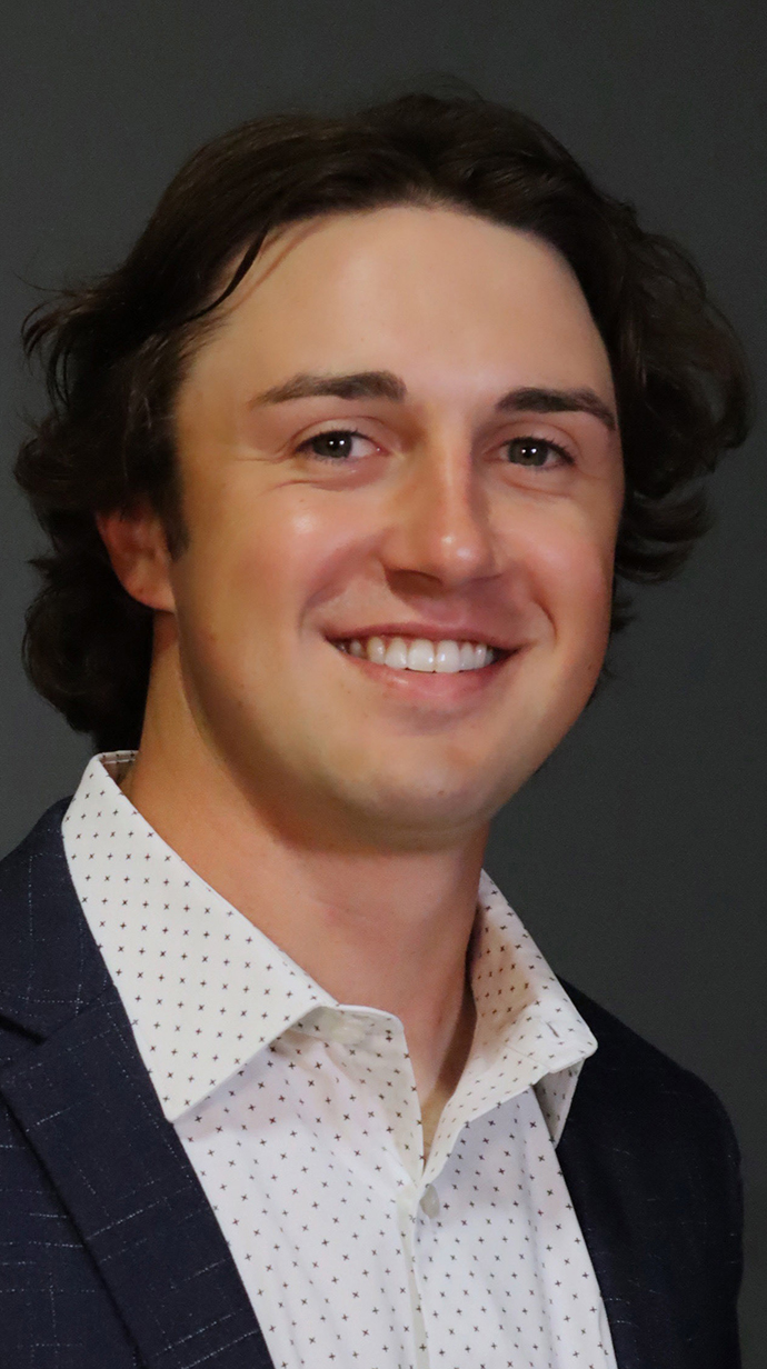 Headshot of a young man wearing a dark jacket over an open-collared dress shirt.