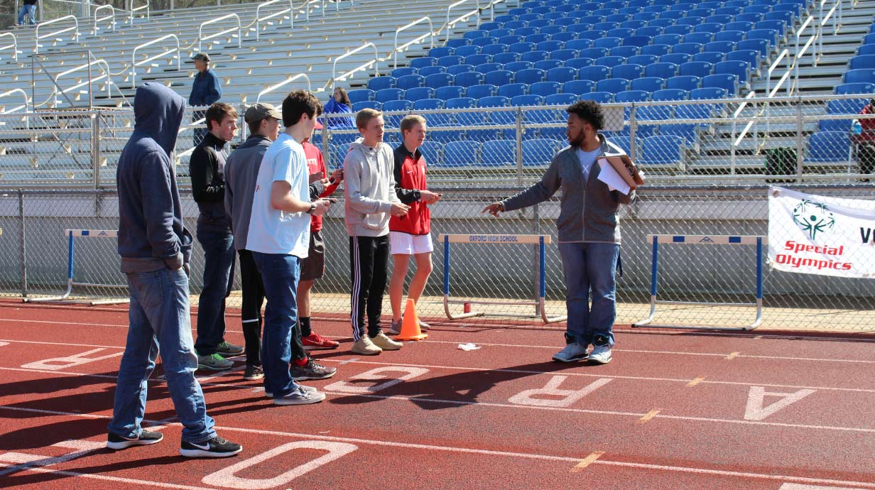 Bachelor of Arts in Sport and Recreation Administration student talks to a group on a track.
