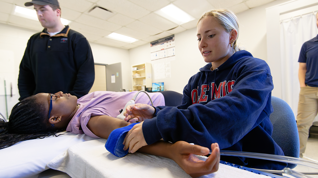 Ph.D. in Health and Kinesiology students participate in hands-on clinical training in a healthcare lab setting.