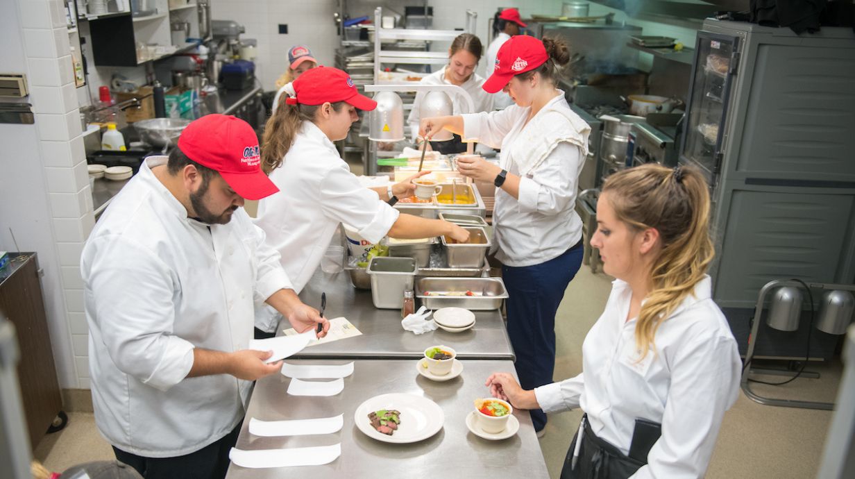 Master of Science in Hospitality Management students work in a kitchen on campus.