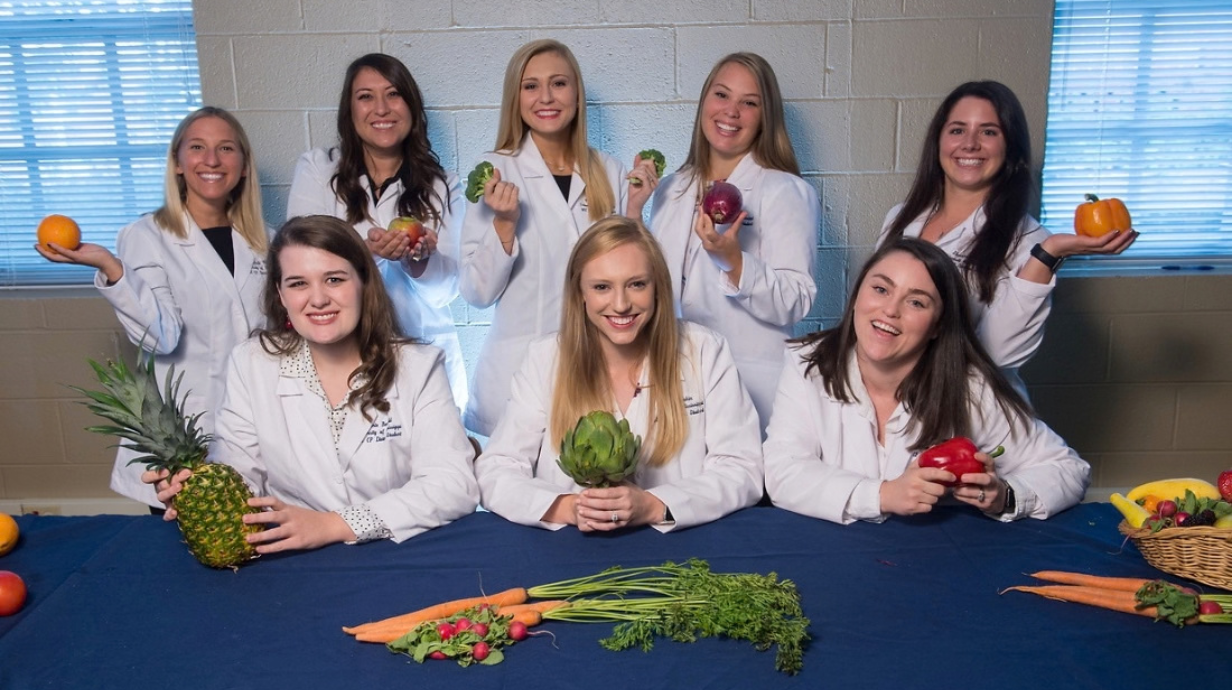 Ph.D. in Nutrition Sciences students in white coats - nutrition display